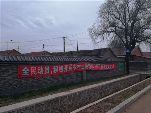 圖為村路邊墻上掛著醒目的宣傳條幅。.png